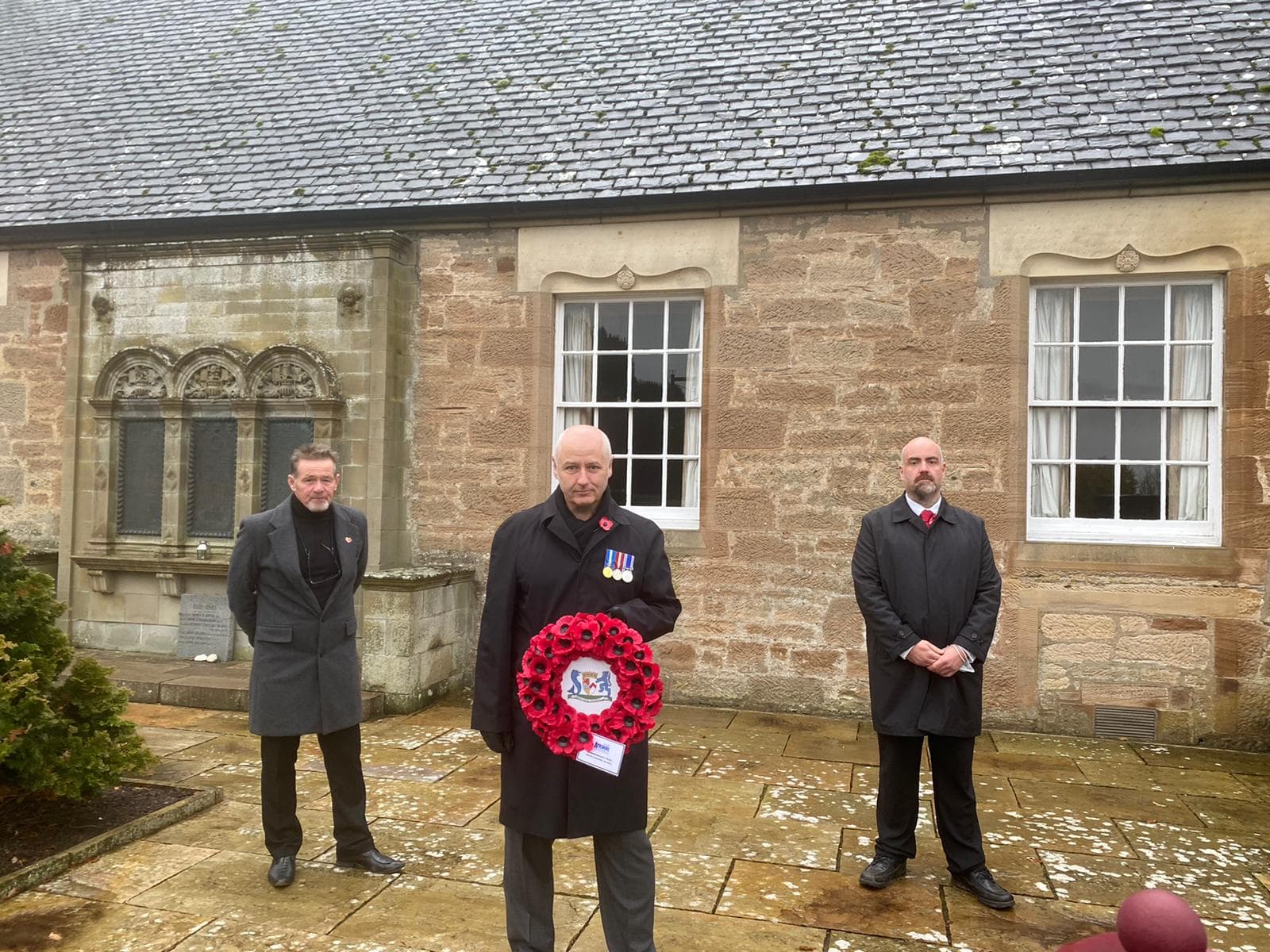 Cllrs Derek McCabe, Martin Dowey, and Lee Lyons laying a wreath to commemorate Commonwealth soldiers for Rememberance Sunday in Alloway.